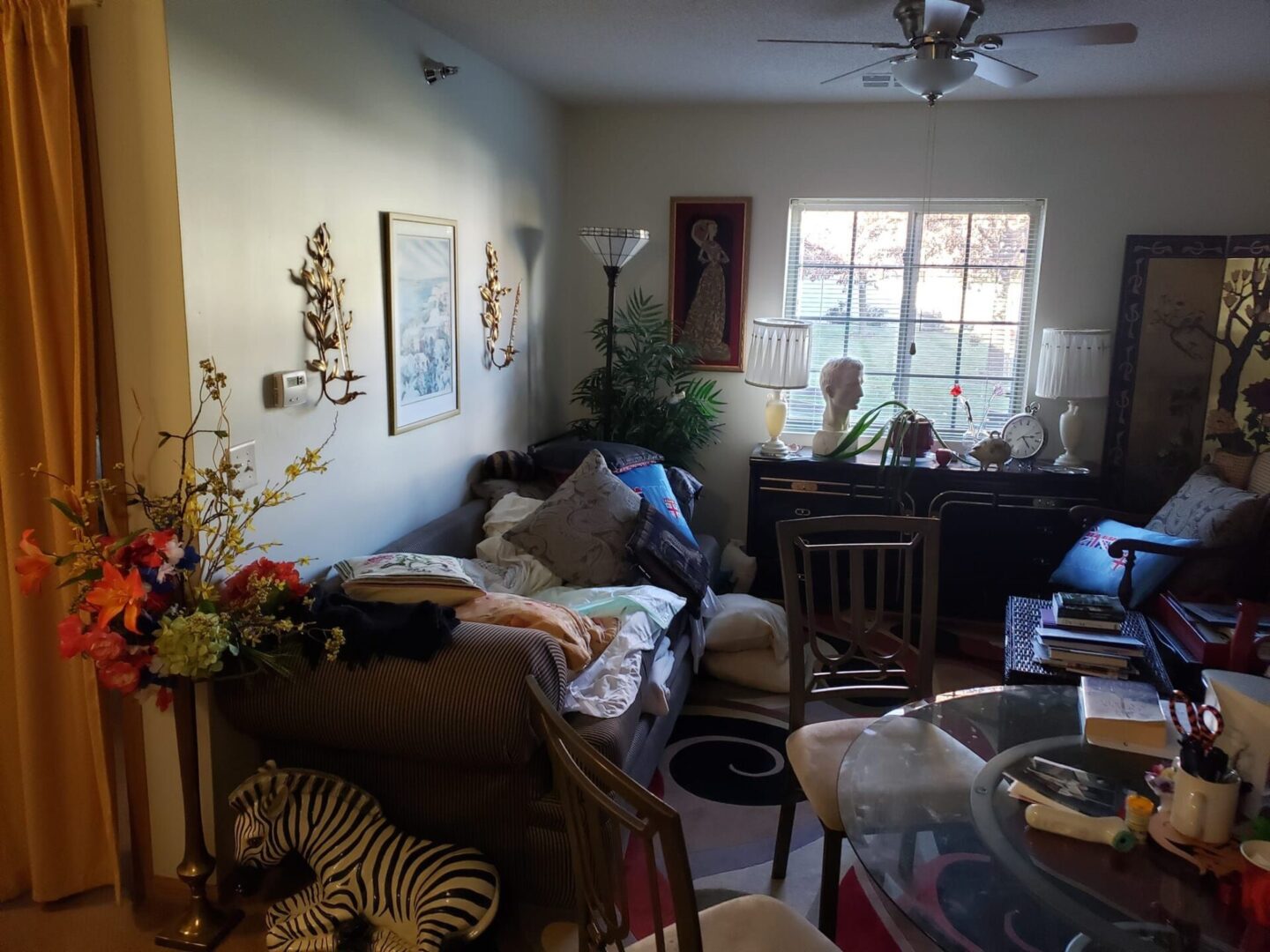 A living room with furniture and two people sitting at the table.