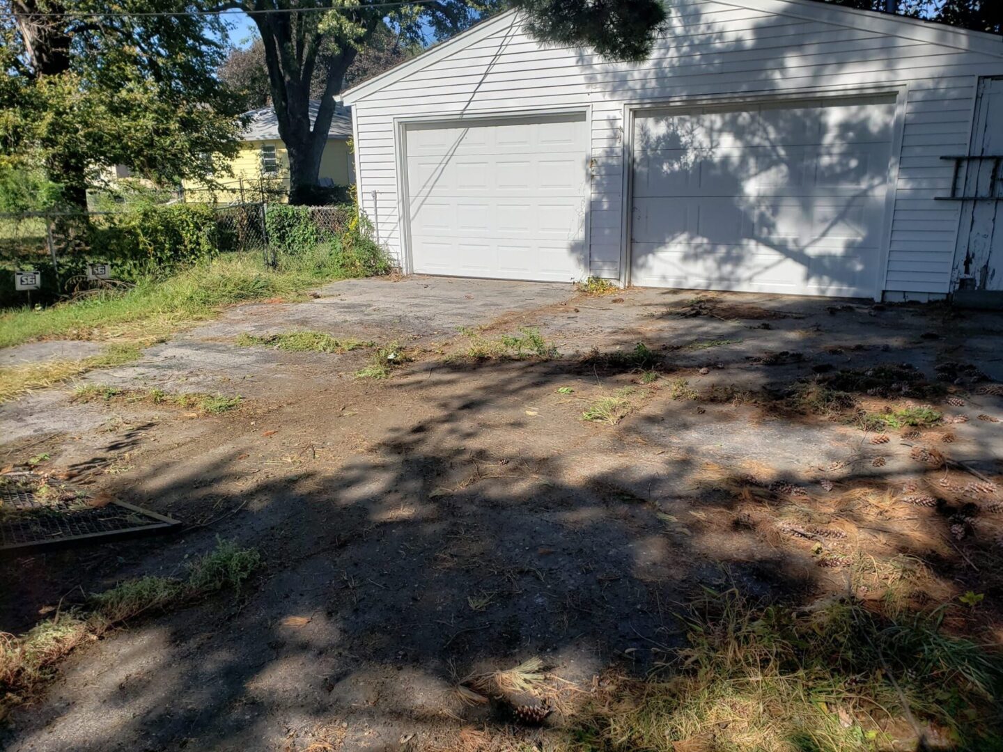 A white garage with trees in the background